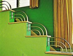 a green wall with some stairs and curtains