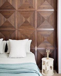 a bed sitting next to a wooden wall