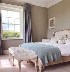 a bedroom with a bed, bench and window in it's centerpieces