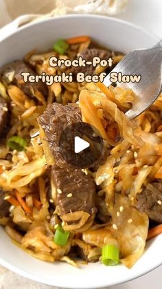 a bowl filled with beef and noodles on top of a white table next to a fork