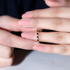 a woman's hand with pink manicures and a ring on her finger