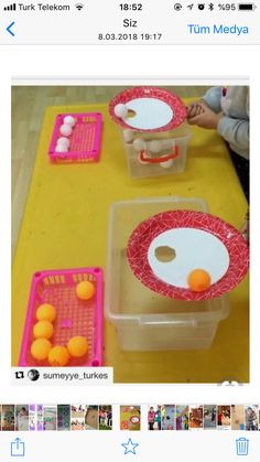 two plastic containers filled with oranges sitting on top of a yellow table covered in photos