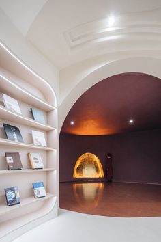 a person standing in front of a book shelf with books on it and an archway leading into the room