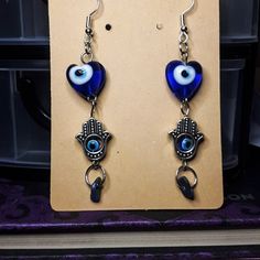 Beautiful Evil Eye Earrings! An evil eye is a talisman or amulet, designed in the shape of an eye, traditionally in the colours blue or green, that indicate spiritual protection. All jewelry comes with crystal crumbs! Pride Necklace, Spiritual Protection, Evil Eye Earrings, Wire Wrapped Necklace, Eye Earrings, Evil Eye Jewelry, Eye Jewelry, Blue Bracelet, Evil Eye