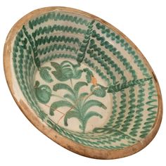 a green and white bowl sitting on top of a table