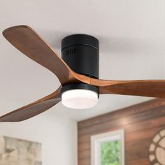 a black ceiling fan with wooden blades in a living room