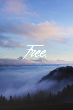 the words free are written in white over a foggy mountain landscape with trees and mountains