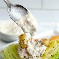 a spoon scooping some food out of a lettuce wrap on a plate