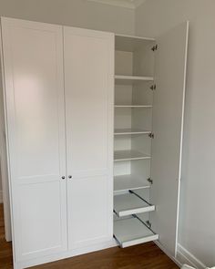 an empty room with white closets and wooden floors