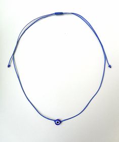 Evil eye choker necklace, String choker, Minimalist The evil eye is used to protect the person that wears it from the malevolent look of others who envy or dislike that person. The necklace is made with 1mm black waxed string,and has a 8mm blue glass evil eye bead. At the end it is adorned with seed beads. Total length: 80cm / 31 inches It is adjustable to fit a lot of sizes. Custom orders for different colour combinations are welcome. Other necklaces in my shop: https://www.etsy.com/shop/LuckyR Festival Jewelry With Adjustable Nylon Cord, Festival Jewelry With Sliding Knot On Nylon Cord, Adjustable Knot Nylon Cord Jewelry For Festival, Blue Necklace With Adjustable Length For Gifts, Minimalist Blue Jewelry With Adjustable Cord, Evil Eye Choker Necklace As Gift, Evil Eye Choker Necklace For Gift, Handmade Blue Necklaces With Waxed Cord, Handmade Spiritual Jewelry With Nylon Cord