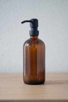 a brown glass bottle with a black top