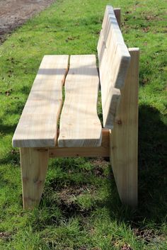 a wooden bench sitting on top of a lush green field