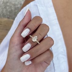 a woman's hand with white manies and a gold ring on it,