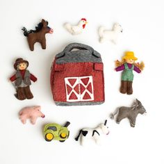 felt farm animals and toys are arranged in the shape of a barn