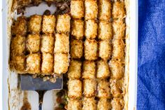 a casserole dish with tater tots in it and a spatula