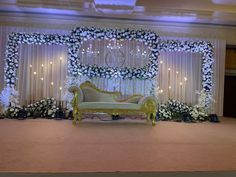 the stage is decorated with white flowers and greenery for an elegant wedding or reception