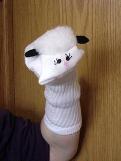 a person wearing white socks with black feet and sheep's head sticking out of the sock