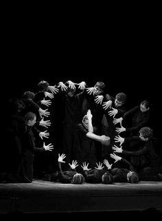 a group of people standing on top of a stage with their hands in the air