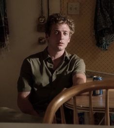 a man sitting at a table with his arms crossed and looking off to the side