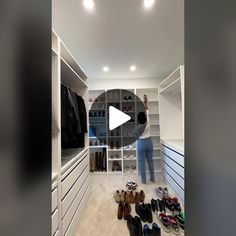 a person standing in front of a closet with shoes on the floor and shelves full of clothes