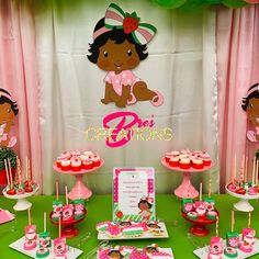 a table topped with cupcakes and cakes covered in pink frosting