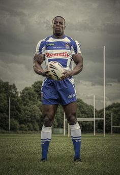 a man holding a soccer ball on top of a field