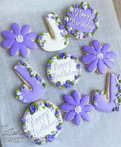 decorated cookies with purple flowers and happy birthday written on them