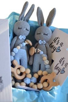 two crocheted rabbits sitting next to each other on top of a blue box