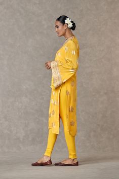 Adorned with embroidered borders, this outfit showcases bell sleeves and a 'V' neck. The kurta features a beautiful parijat print, perfectly complemented by a yellow legging, creating a vibrant and stylish ensemble. Yellow Anarkali Kaftan For Festive Occasions, Yellow Palazzo Set With Dabka Straight Kurta, Festive Kurta With Set-in Sleeves, Yellow Anarkali Set With Dabka, Yellow Long Sleeve Palazzo Set With Chikankari Embroidery, Fitted Kurta With Set-in Sleeves For Festive Occasions, Fitted Long Sleeve Traditional Wear With Gota Work, Yellow Palazzo Set With Dabka For Festivals, Yellow Dabka Palazzo Set For Festivals