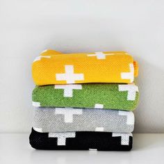 four towels stacked on top of each other in different colors and patterns, all folded neatly