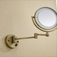 a wall mounted magnifying mirror on the side of a door with a light