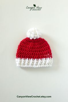 a red and white crocheted hat on top of a table