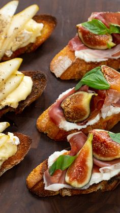 toasted bread topped with figs, cheese and other toppings on a wooden table