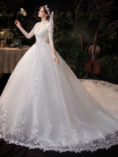 a woman in a white wedding dress standing next to a table with flowers on it