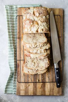 sliced loaf of bread sitting on top of a cutting board next to a knife