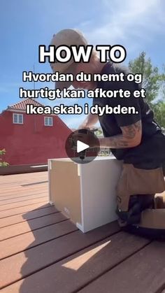 a man sitting on top of a wooden floor next to a box with an object in it