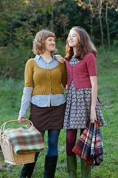 two women standing next to each other in the grass