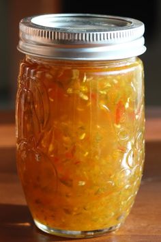 a jar filled with liquid sitting on top of a wooden table