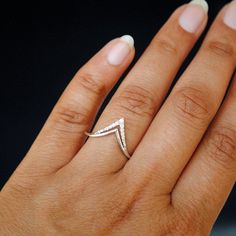 a woman's hand with a diamond ring on top of her left hand,