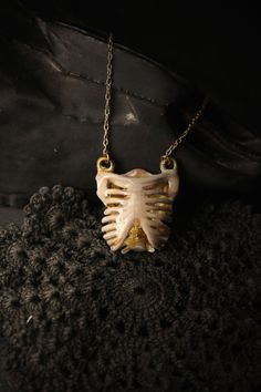 ** Unique Human Rib Cage Charm Necklace / Hand - Painting Version- Original Design and Made by Defy ** Another cool item in our Human Anatomy collection. The pendant is made of brass material with gold-plated chain. The skull has nice handmade details in color hand paint tones. Product info ; - The Human Rib Cage Dimensions are : approx. 2.7 x 2.9 x 1.2 cm. - Necklace chain length : please choose our length options - Material : brass (nickel free) - Claw Clasp **Shipping to World Wide** - Please Unique Bone-colored Jewelry For Gift, Unique Bone-colored Brass Jewelry, Unique Brass Jewelry In Bone Color, Handmade Metal Jewelry In Bone Color, Bone Colored Metal Jewelry Gift, White Gothic Necklace Gift, Gothic Brass Jewelry Gift, Unique Bone-colored Metal Jewelry, Bohemian Gold Jewelry For Halloween