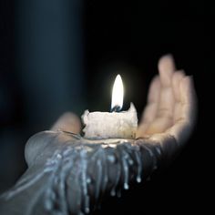 a person holding a lit candle in their hand