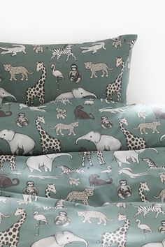 an elephant and giraffe print bedding set with matching pillow cases in blue