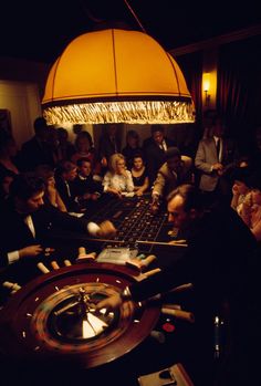 a group of people playing roulege in a dark room