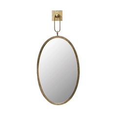 an oval mirror hanging from the wall with a metal hook on it's side