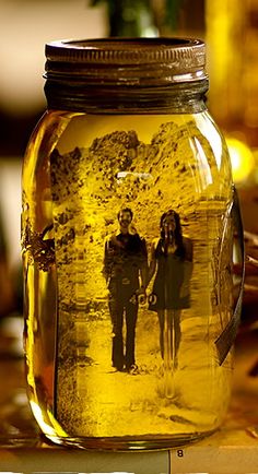 a jar filled with yellow liquid sitting on top of a table