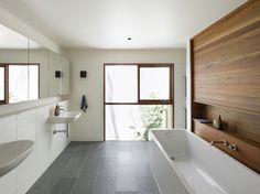 a bathroom with a large bathtub next to a sink and window on the wall