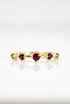 This striking ruby ring features AAA quality round cut rubies on 14K yellow gold. A unique statement piece to add to your collection. A wonderful alternative to a traditional wedding band. Ruby is also the July birthstone for all you July babies! Please drop your finger size in the notes section at checkout. Please be aware international buyers are responsible for duties and fees. Yellow Gold Ruby Ring With Round Cut Lab-created Ruby, Yellow Gold Stackable Ruby Ring, Yellow Gold Stackable Ruby Rings In Round Cut, 14k Gold Ruby Promise Ring With Round Cut, Yellow Gold Ruby Birthstone Ring With Round Band, Yellow Gold Stackable Ruby Rings Round Cut, Yellow Gold Ruby Birthstone Ring, Yellow Gold Birthstone Ring With Round-cut Lab-created Ruby, Yellow Gold Birthstone Ring With Round Cut Lab-created Ruby