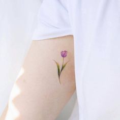 a small purple flower on the left side of the arm