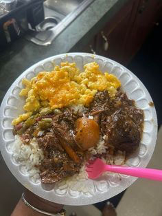 a paper plate with rice, meat and eggs on it