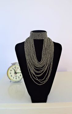 Unique Africa Maasai Handcrafted Beaded Necklace with an Elegant Look and Brilliant Finish. Color = Silver Gray. Length (Around Neck) = Adjustable. Length ( Downwards ) = 11.5 Inches / 30 Centimeters. **GET FREE SHIPPING FOR ADDITIONAL ITEMS PURCHASED. Yes, Buy Multiple Items and pay shipping for 1 item only- The rest ships Free. (No Limits on the number of Multiple items). With a faster delivery time of 3 days via DHLExpress, Worldwide. Ordinary/Standard Shipping also available upon request. We Silver Chain Choker For Festivals, Bohemian Gray Beaded Jewelry, Silver Metal Choker With Beaded Chain, Silver Metal Beaded Chain, Bohemian Long Necklace Beads In Silver, Bohemian Gray Beaded Necklaces, Silver Bohemian Long Necklace Beads, Adjustable Gray Bohemian Beaded Necklace, Gray Bohemian Necklace With Round Beads